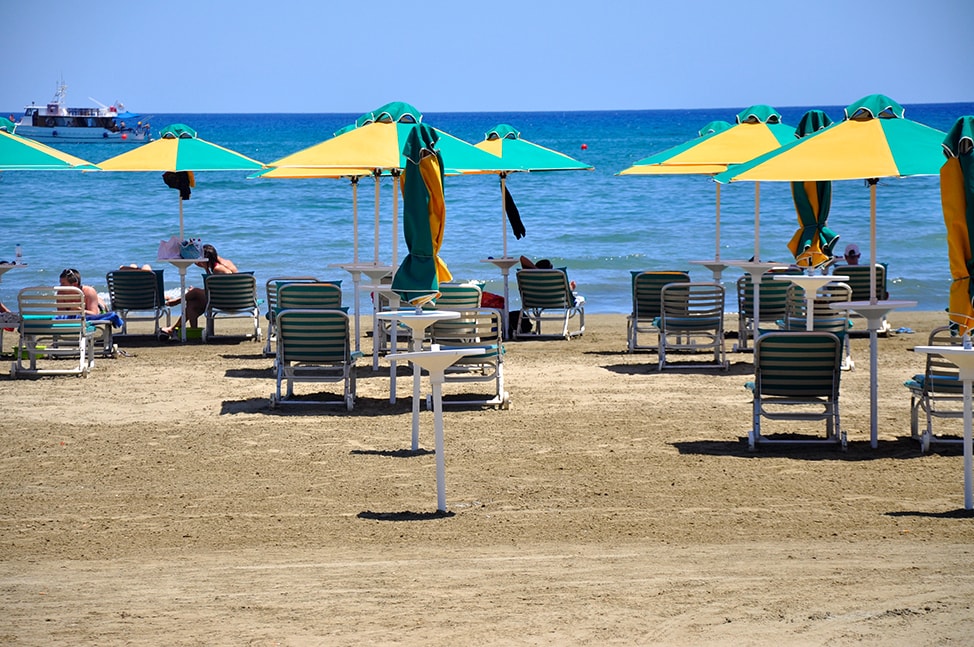 Yellow and Green Beach Umbrellas line the beach in Larnaca. 