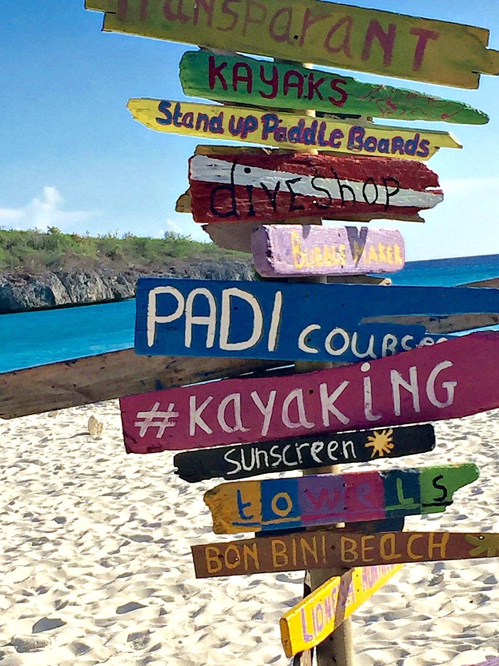 Colorful, rustic sign on the beach in Curaçao