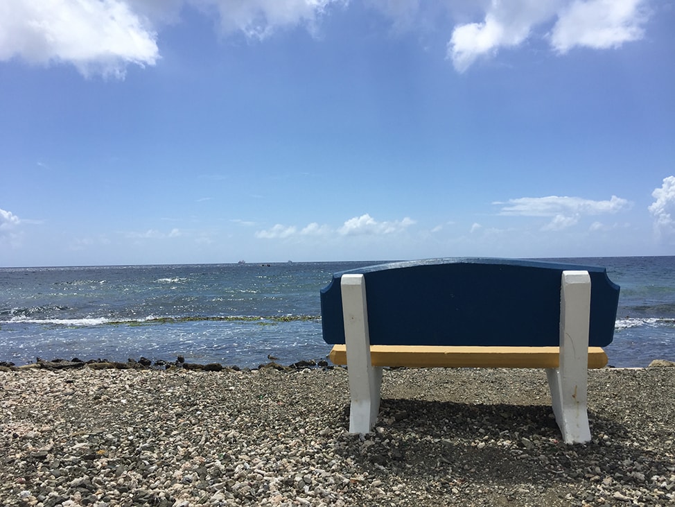 An empty bench along the water's edge in Curaçao