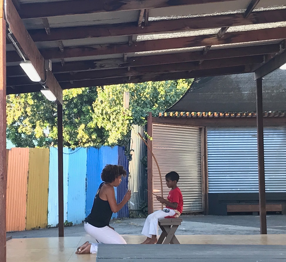 Teaching a child to play the berimbau as a part of capoeira class