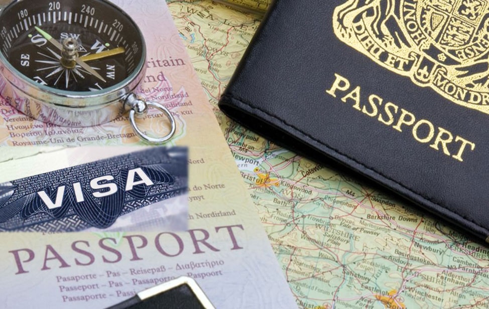 Photo of passport holder, maps a compass and a visa stamp