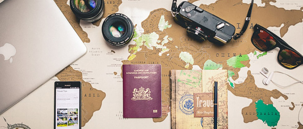 Flat lay of travel items - camera, laptop, passport, journal, passport