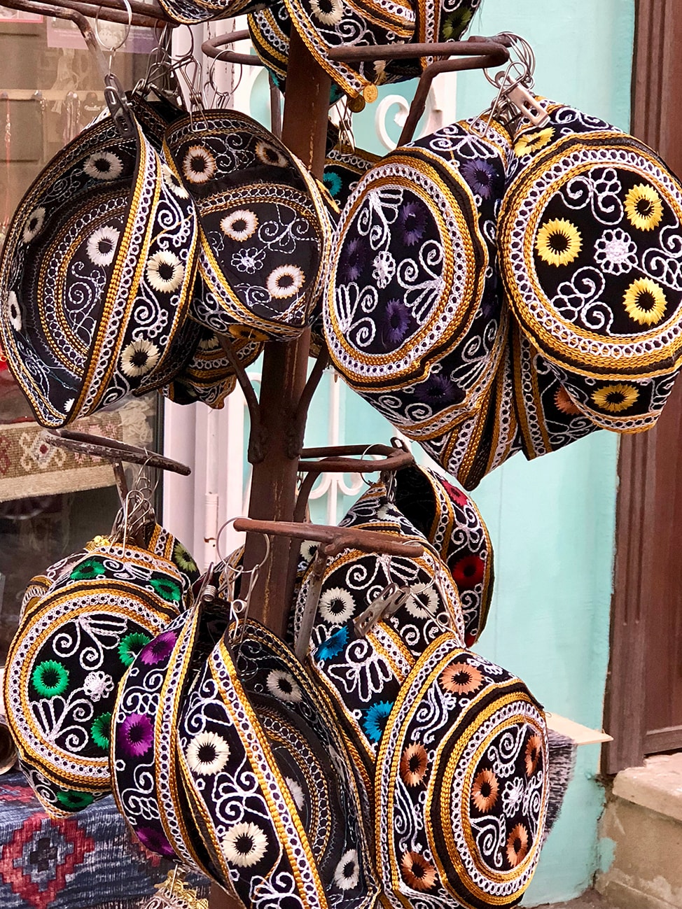 Colorful embroidered hats hanging for sale in Baku