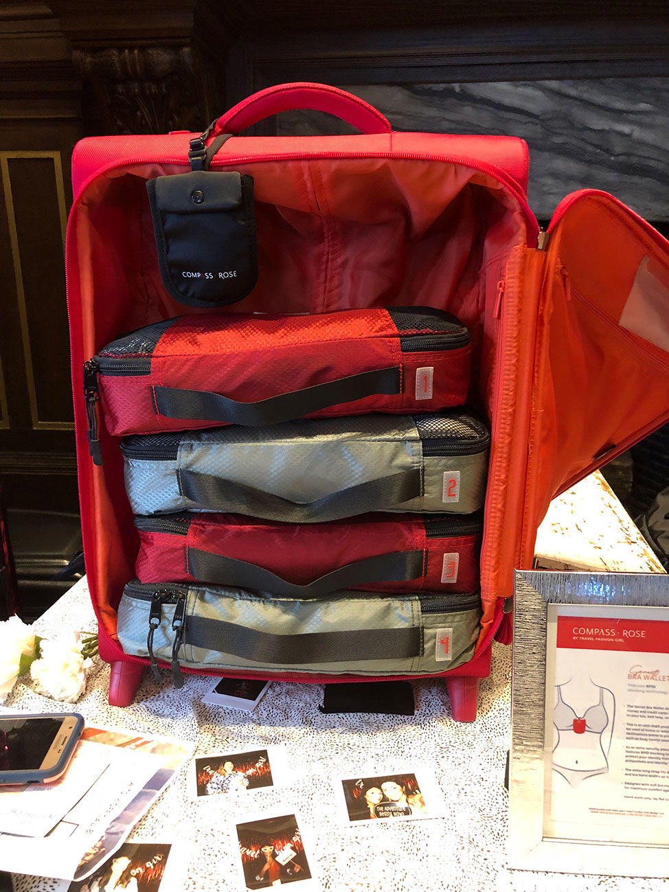 Image of Compass Rose Packing Cubes in a signature red roll aboard suitcase
