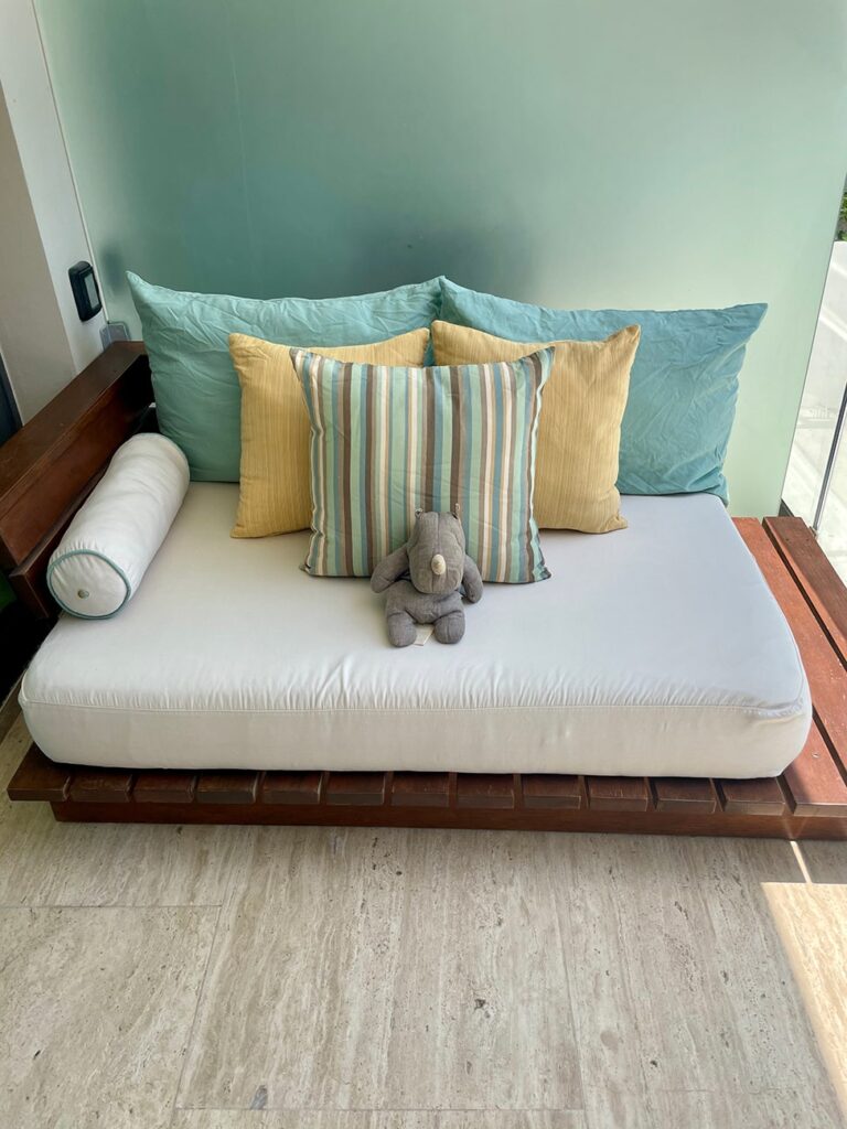 Sai the Travel Rhino enjoying the daybed on the room balcony at the Thompson Beach House.