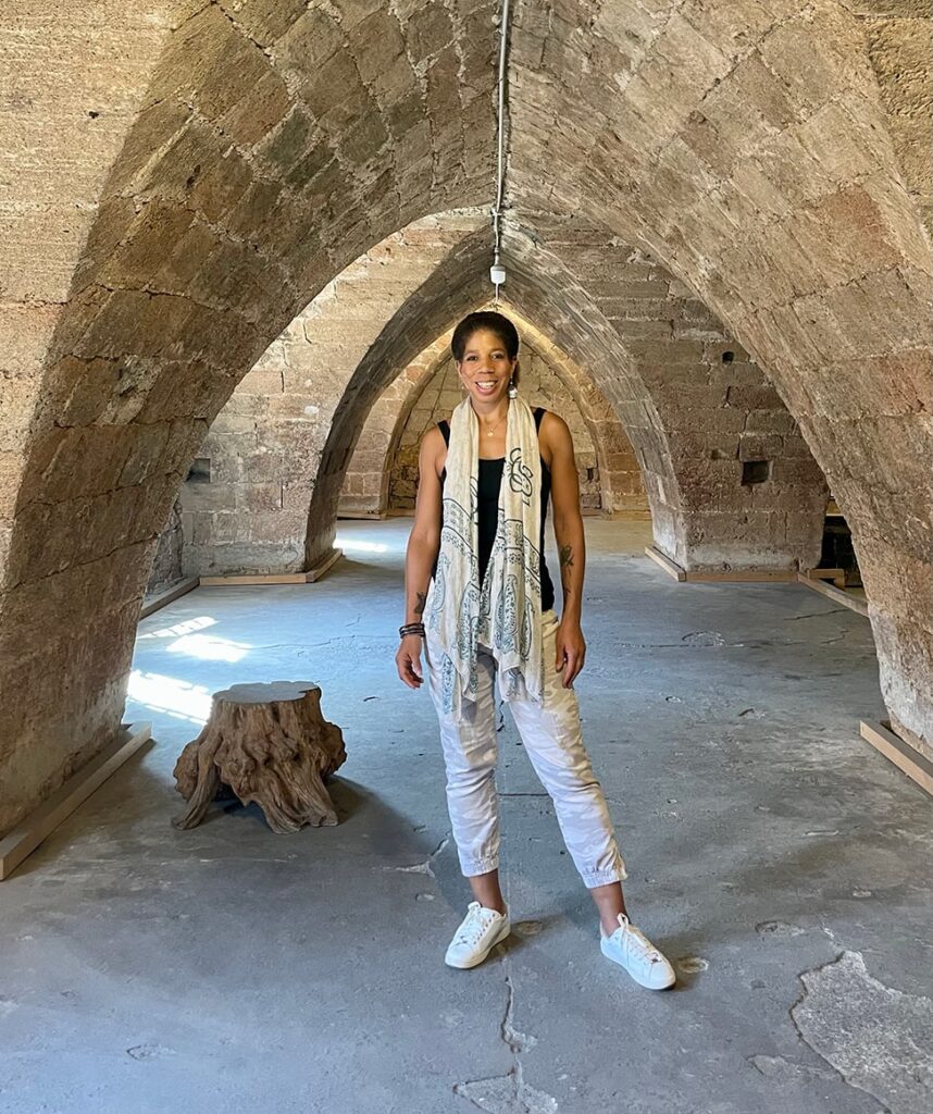 The author standing under brick arches in Tripoli, Lebanon wearing the sneakers that were key to pack for a month of travel. 