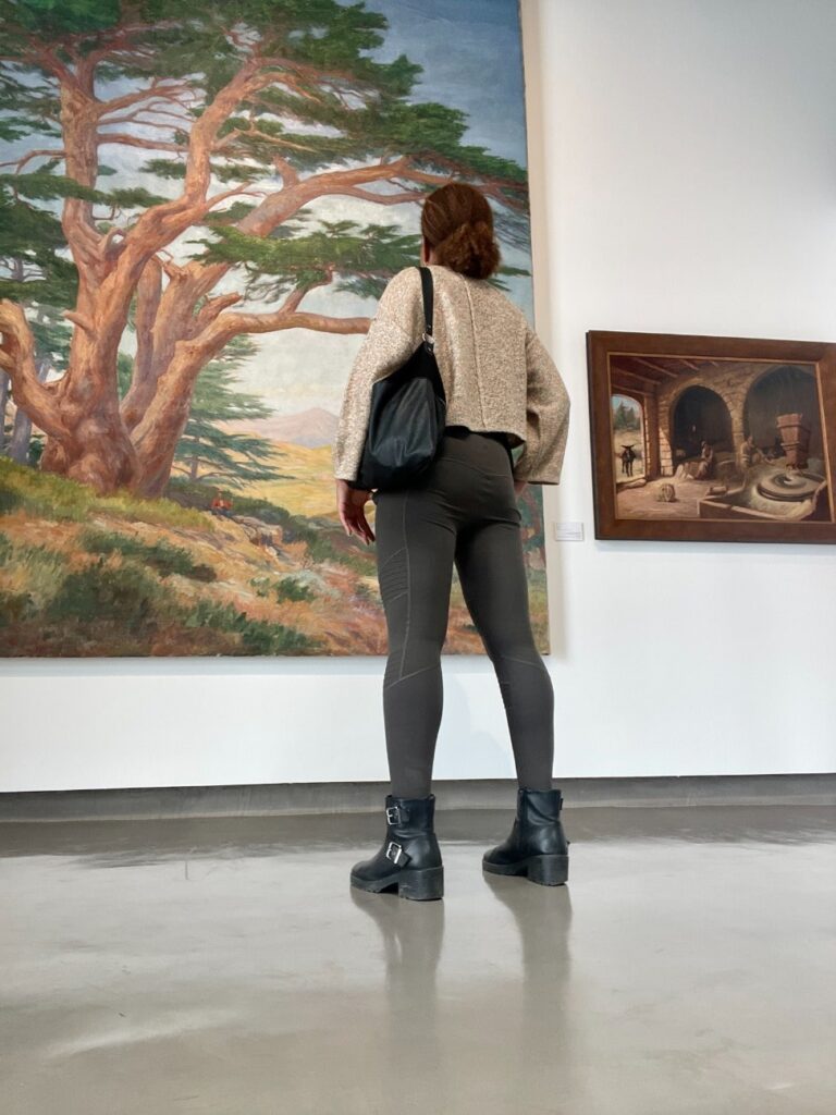 View of the author's back as she admires a painting in a Lebanese museum. 